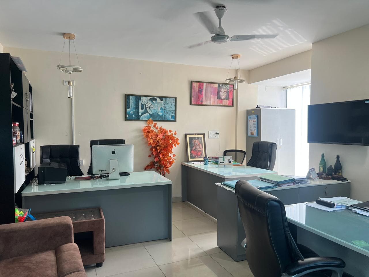The B-Cube counselling room with desks, a desktop computer, framed artwork and a sofa